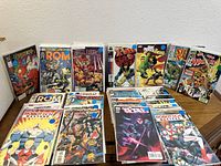 Overview of vintage comic books including Marvel, DC, and Comico titles, showing front covers and arrangement on a table.