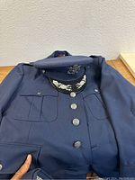 Navy blue military jacket with official silver buttons and matching hat
