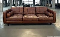 Full front view of large brown leather sofa set in warehouse