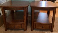 Pair of brown veneer end tables with drawer and lower shelf storage, shown side by side.