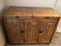 Front view of closed buffet table showing three door panels with rectangular pattern design and metal handles.