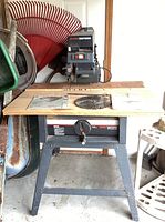 Full view of Craftsman radial arm saw mounted on steel stand in garage