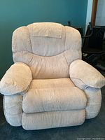 Frontal view of the cream La-Z-Boy recliner chair showing broad padded arms and backrest.
