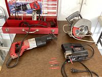 Photo of the Milwaukee Sawzall, Skilsaw circular saw, Sears Craftsman Sabre Saw, and blades on a table with the red toolbox open in the background.
