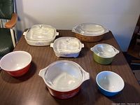 Overview of all vintage Pyrex and Corningware cookware pieces on table