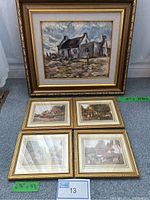 Photo showing the large framed oil painting with four smaller framed countryside prints laid out below it. The paintings and prints depict English countryside scenes with buildings and rural life.