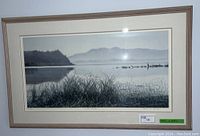 Framed black and white landscape print showing water, tall grass, distant trees, and mountains, matted and framed with dimensions labeled 41 x 25 inches.