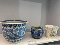 Photo of all three ceramic plant pots arranged from largest to smallest on a white shelf.