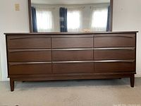 Front view of the mid-century modern 9-drawer dresser showing drawer fronts and handles, wood finish, and condition.