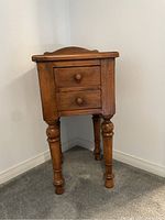 Full side-angle view of the wood accent table against a wall.
