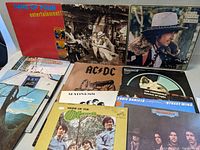 Photo showing 10 vinyl records arranged in two rows, featuring artists such as Gang of Four, Lynyrd Skynyrd, AC/DC, Madness, The Monkees, Eddie Daniels, Bob Dylan, The Eagles, Led Zeppelin.