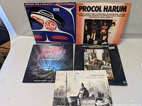 Photo showing all five vinyl record albums arranged upright and flat, featuring visible cover art and titles for identification.