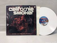 Front view of California Smoker album cover with white vinyl record partially outside the sleeve.