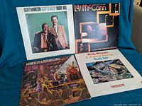 Four classic jazz vinyl LPs arranged on blue cloth background, showing front covers.