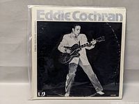 Front cover of Eddie Cochran double vinyl album showing artist playing a guitar in black and white photo with the title and series on the sleeve.