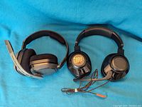 Side-by-side image of JBL and Astro gaming headphones on blue fabric background showing ear cups and headbands.