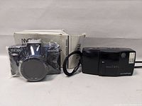 Both Olympus Infinity Twin and Mekai AK-435TKSN cameras with Mekai box in background