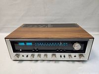 Front angle view of receiver showing wood top and aluminum front face with control knobs and tuning dial