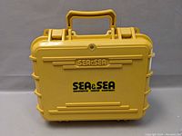 Closed yellow hard plastic Sea & Sea branded carrying case with handle.