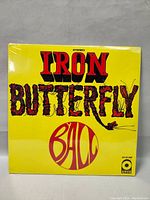 Front cover of Iron Butterfly Ball vinyl album, sealed, yellow with red and black text.