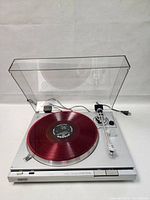 Front view of Sony PS-T22 turntable with clear dust cover open, red vinyl on platter