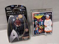 Two Star Trek action figures in packaging: Scotty on the left in black and metallic blister pack, The Keeper on the right in vintage card packaging.