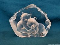 Clear Swedish art glass sculpture showing two bears nestled together with detailed carving and frosted inner texture, resting on a flat base.