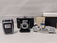 Front view showing Zeiss Ikon Nettar camera, Agfalux light meter, and quick film change pack with box.