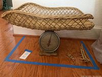 Antique baby scale with wicker basket topper attached, showing scale dial and basket shape