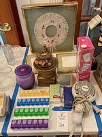 Overview of bath and decorative items including framed textile decor, pill boxes, potpourri stand, cups, small boxes, and hair dryer.