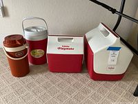 Lot contents with four coolers and thermos placed on carpet showing all sides