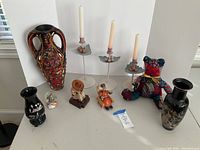 Full lot overview showing all items on table against white backdrop including candleholders, vases, figures, snow globe, and tube container.