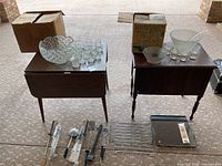 View of vintage Smith Glass punch bowl set with 7 glasses on table alongside metal grill racks, pans and utensils on floor.