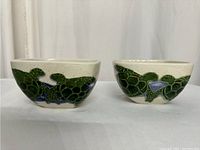 Front view showing two square ceramic bowls featuring green sea turtle and native Hawaiian plant designs on a cream base.