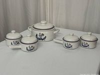 Full view of the vintage ceramic serveware set including one casserole dish and four smaller handled dishes, all with matching lids and rooster design.