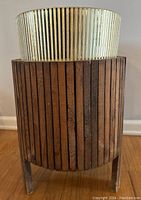 Front view showing vertical dark wood slats and ribbed translucent plastic insert inside