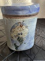 Side view of pottery jar showing mermaid design and speckled glaze