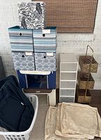 Stacked set of fabric storage bins, white plastic drawer organizer, gold 3-tier metal storage basket, and collapsible beige baskets on floor