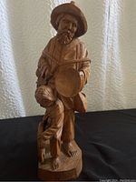 Front view of wood sculpture showing man with banjo and child leaning on him