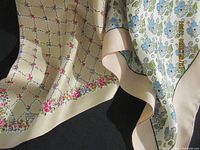 Two Liberty of London scarves displayed together, showing floral patterns and silk sheen.