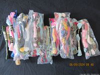 Multiple skeins of embroidery thread in various pastel and bright colors, some sealed in plastic bags.
