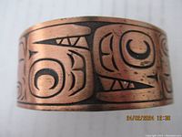 Close-up photo highlighting the detailed First Nations design on the copper bracelet.
