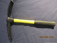 Top-side view of the garden pick showing pointed and flat heads with yellow handle and black grip end.