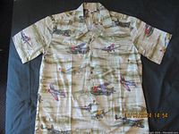 Full view of the vintage Hawaiian short-sleeve shirt laid flat, shows airplane print, camp collar and button-up front.
