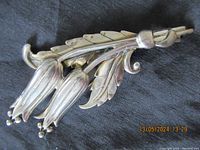 Front angle close-up photo of the Danecraft sterling silver brooch showing flower and leaf design