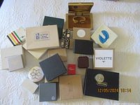 Overview photo showing more than 20 assorted vintage and antique empty jewelry boxes in varied colors and brands