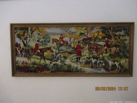 Front view of the full framed needlework depicting a fox hunt, showing riders in red coats, horses, and hunting dogs in outdoor setting