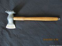 Full view of the meat tenderizer chopper showing the wooden handle and metal double-ended head with flat and textured sides.