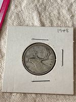 Reverse of the 1948 Canada silver quarter showing a caribou and the date '1948'.