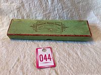 Original green and red trimmed box for dessert utensil set labeled Genuine Rogers Goods with trade mark details.